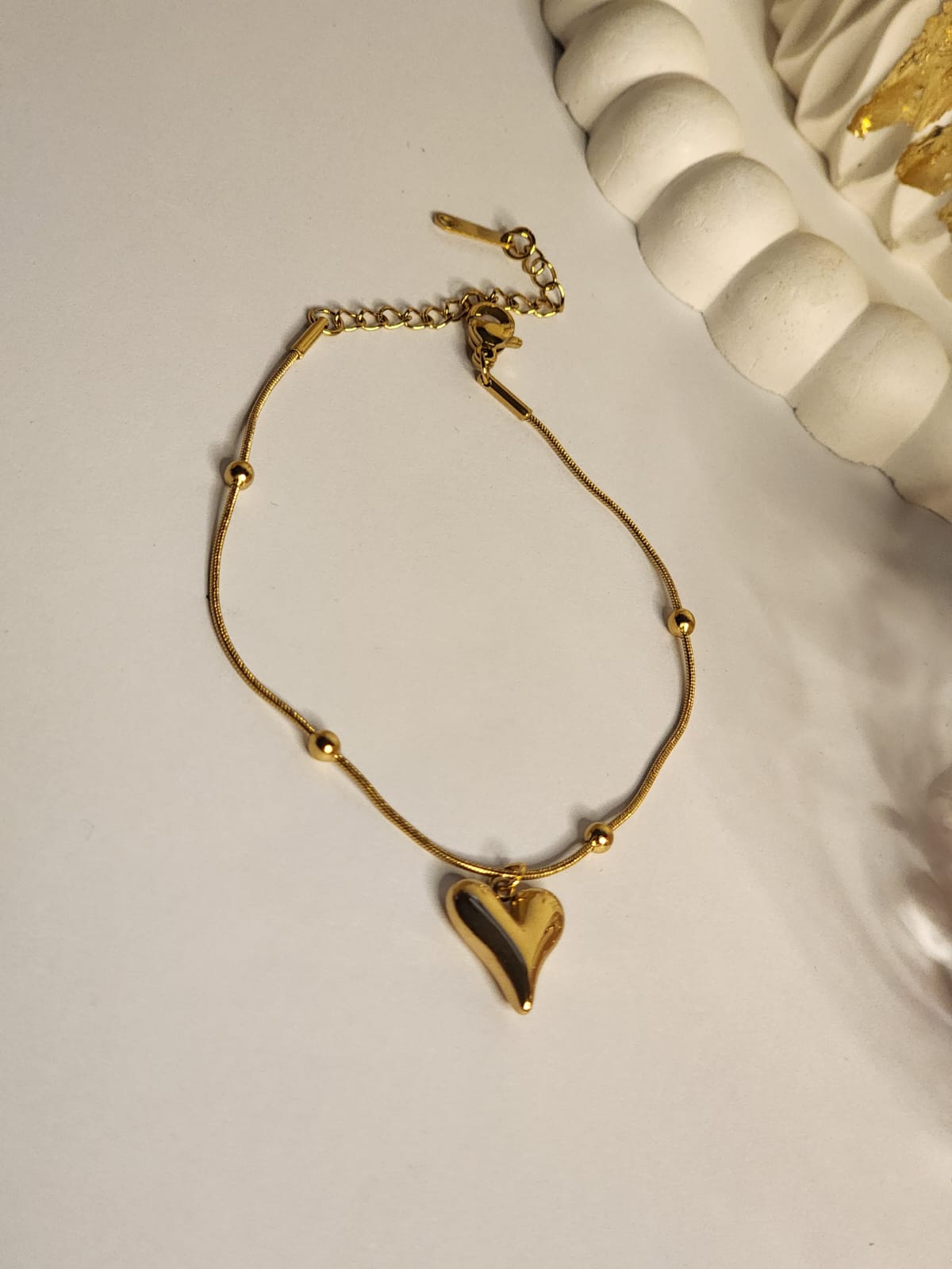 Gold puffy heart charm bracelet full view with lobster clasp and extender chain