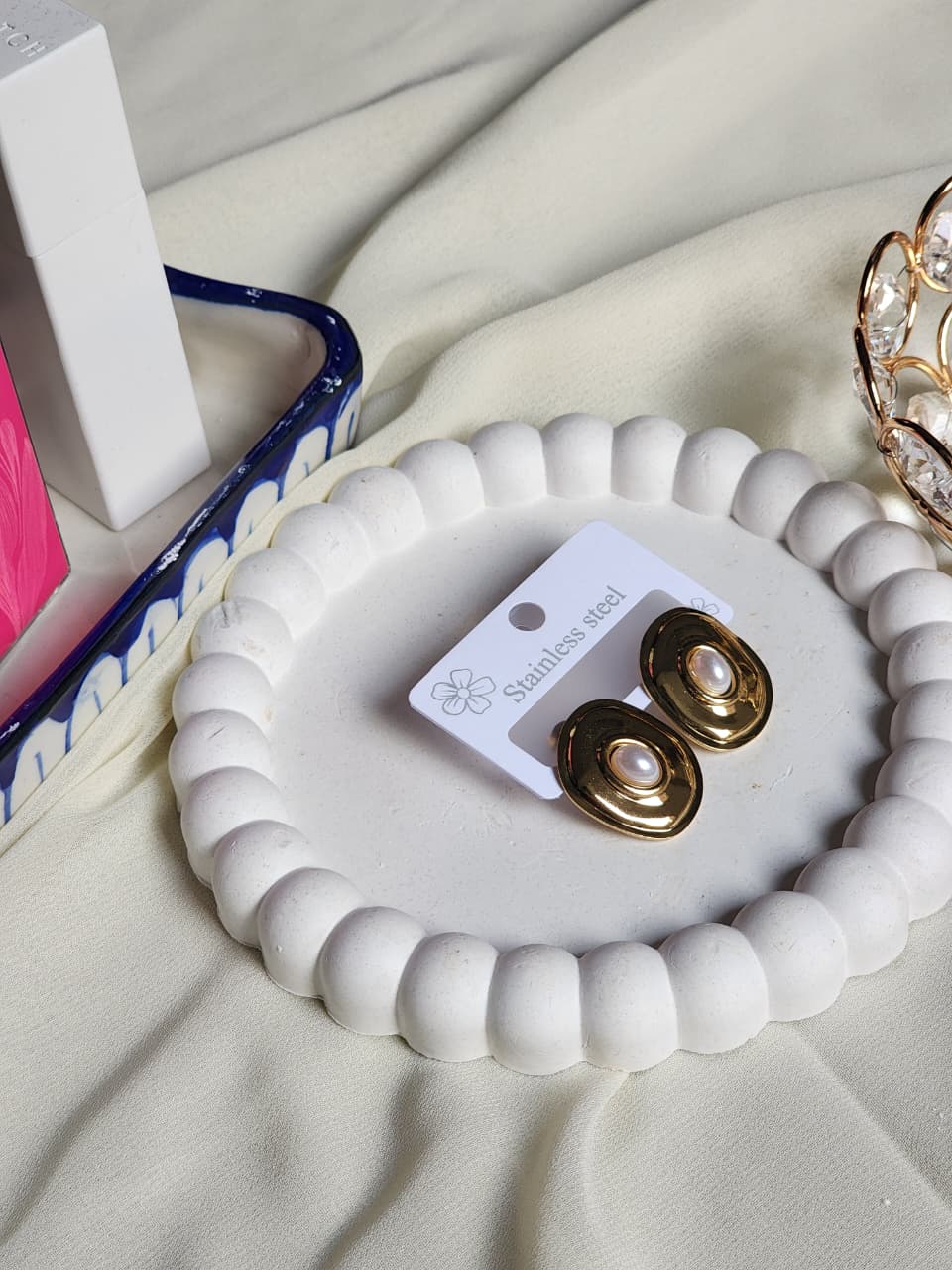 Gold chunky square pearl stud earrings side angle on white display tray