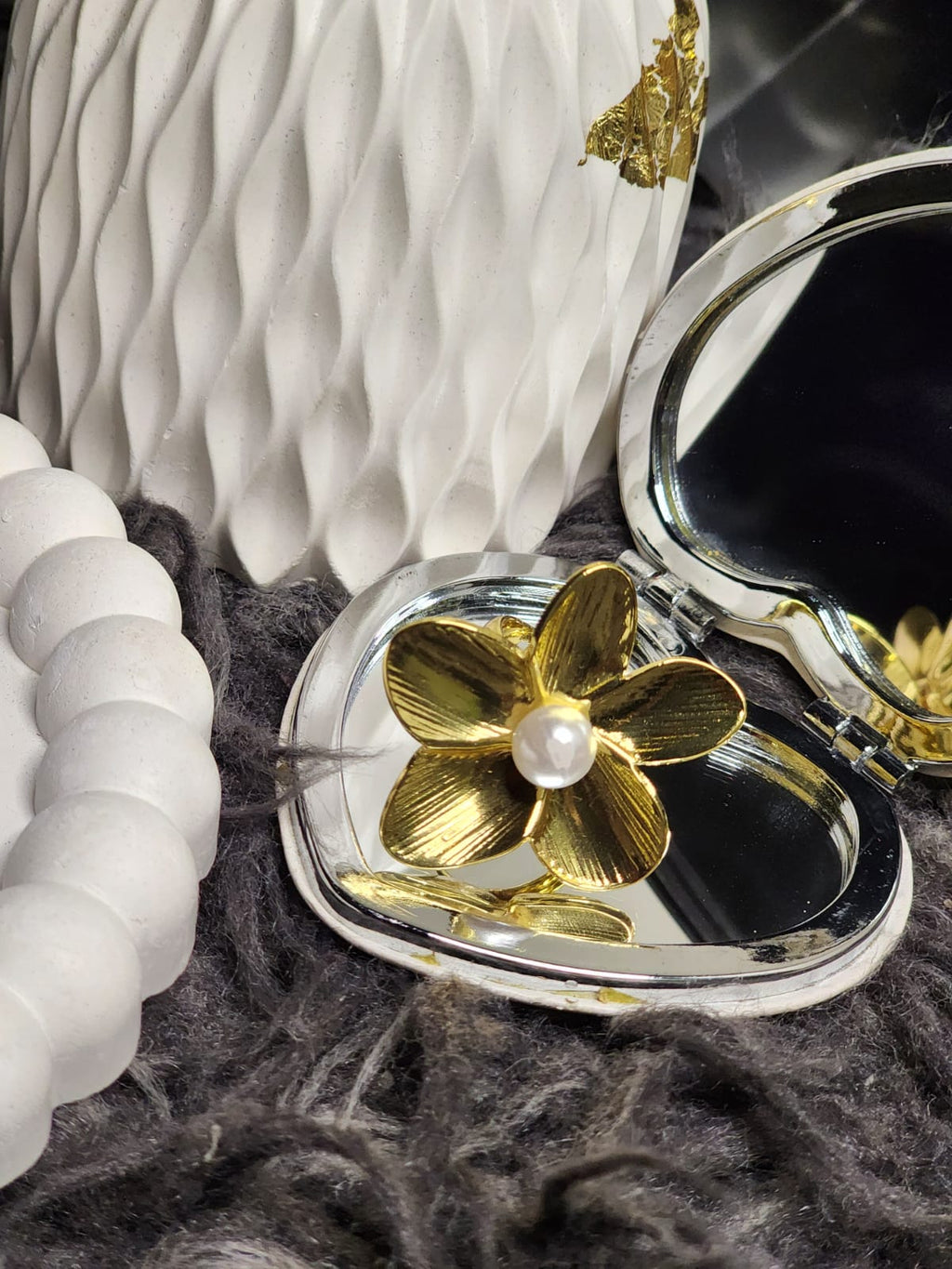 Gold Petal Pearl Ring — flat lay with compact mirror on grey textured background