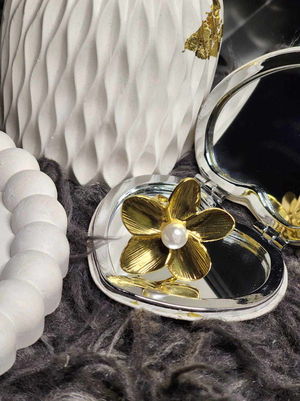 Gold Petal Pearl Ring — flat lay with compact mirror on grey textured background
