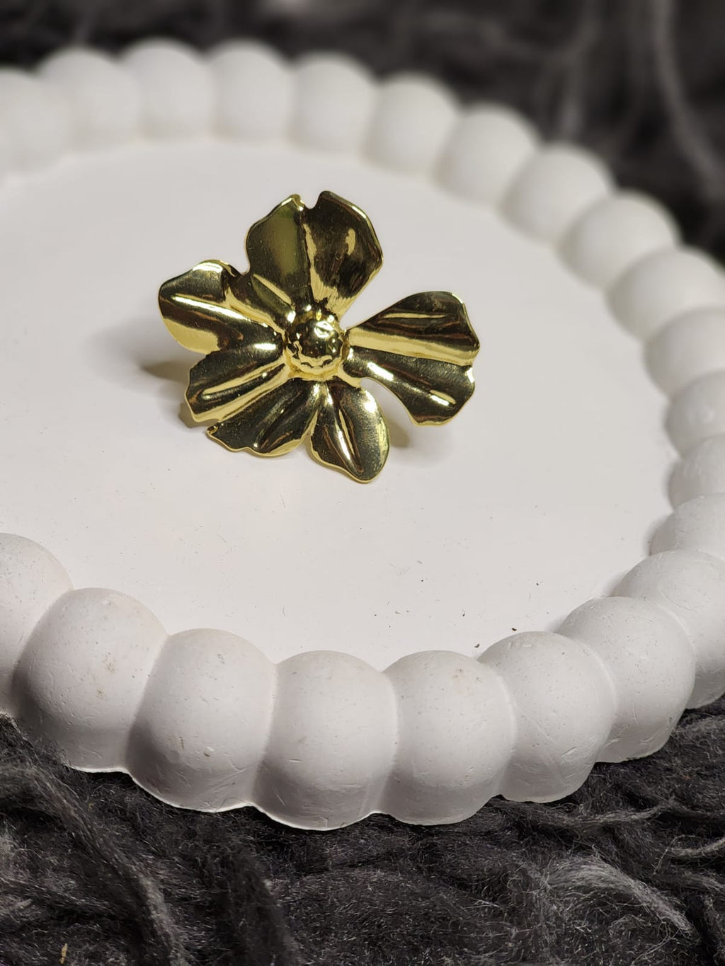 Gold Sculpted Bloom Ring — angled side view showing petal depth on white tray