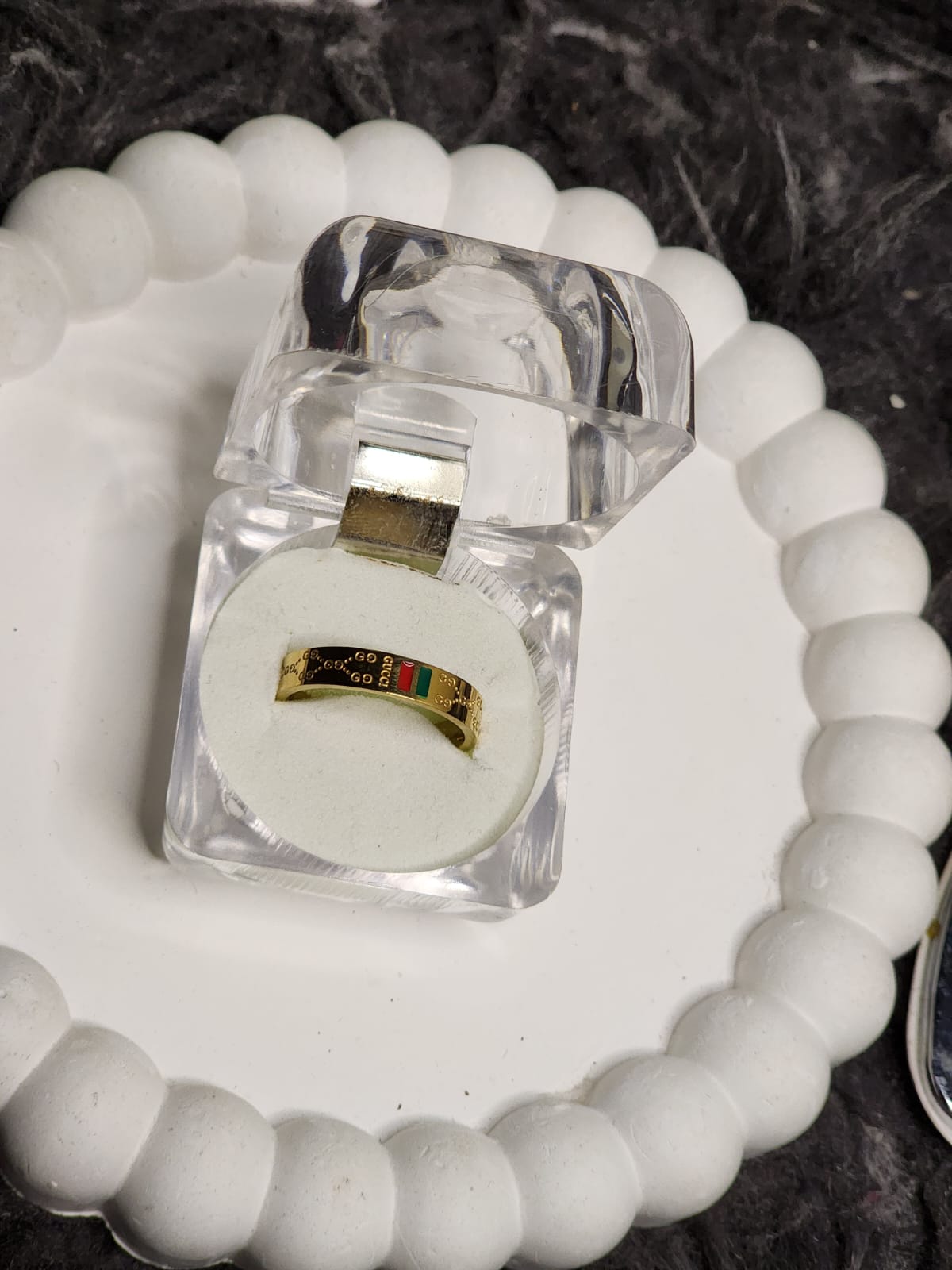 Gold solitaire diamond stack ring set in clear acrylic gift box on white scalloped tray