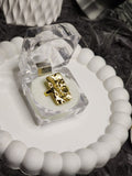Gold hammered rectangle ring in clear acrylic gift box on white scalloped tray