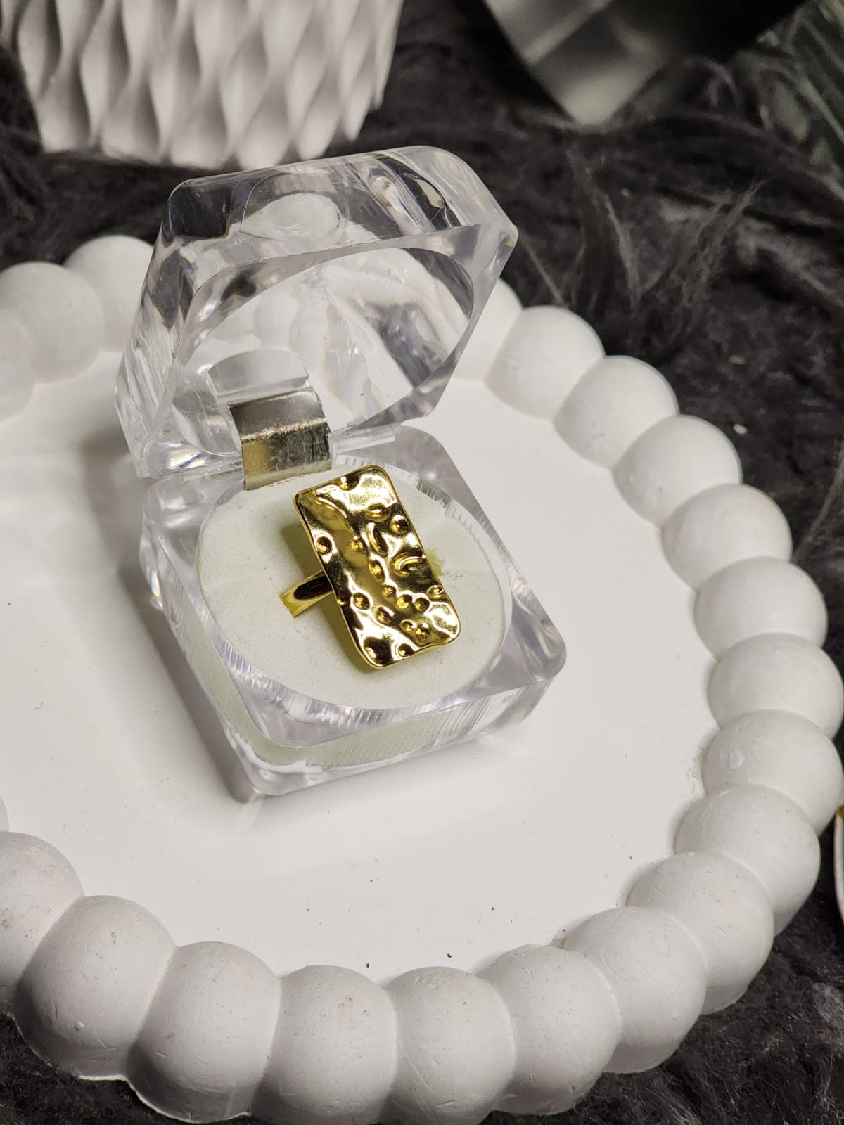 Gold hammered rectangle ring in clear acrylic gift box on white scalloped tray