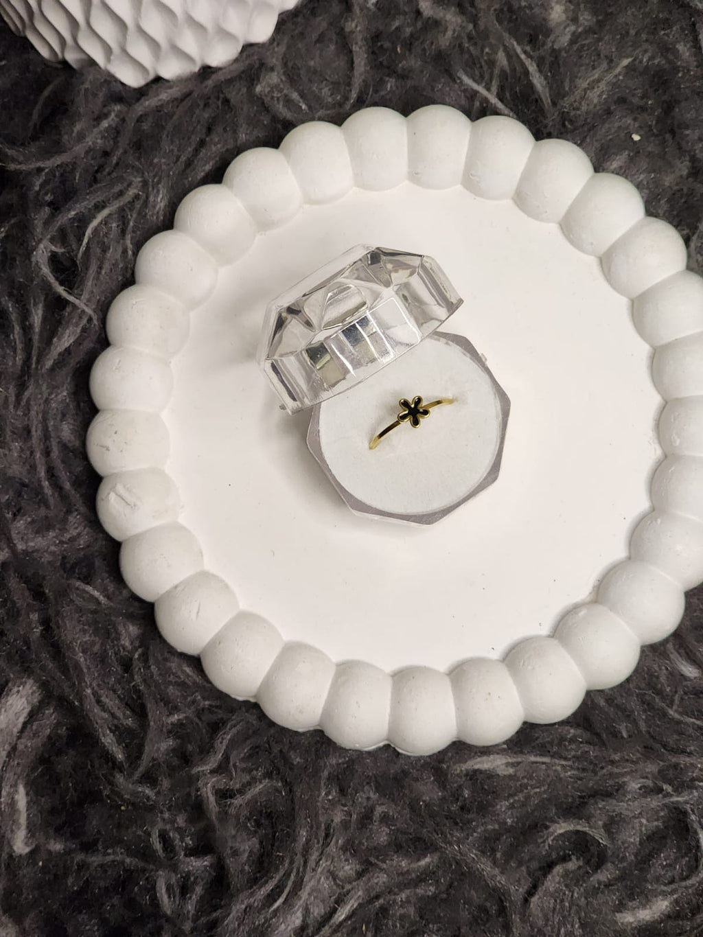 Black flower gold ring in clear acrylic gift box on white scalloped tray