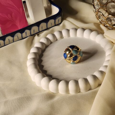 A bold, spherical gold dome ring featuring a mosaic cluster of smooth cobalt blue, seafoam green, and polished gold cabochons.