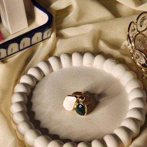 Modern duo-shape statement ring featuring abstract white and deep green organic forms with a gold finish.